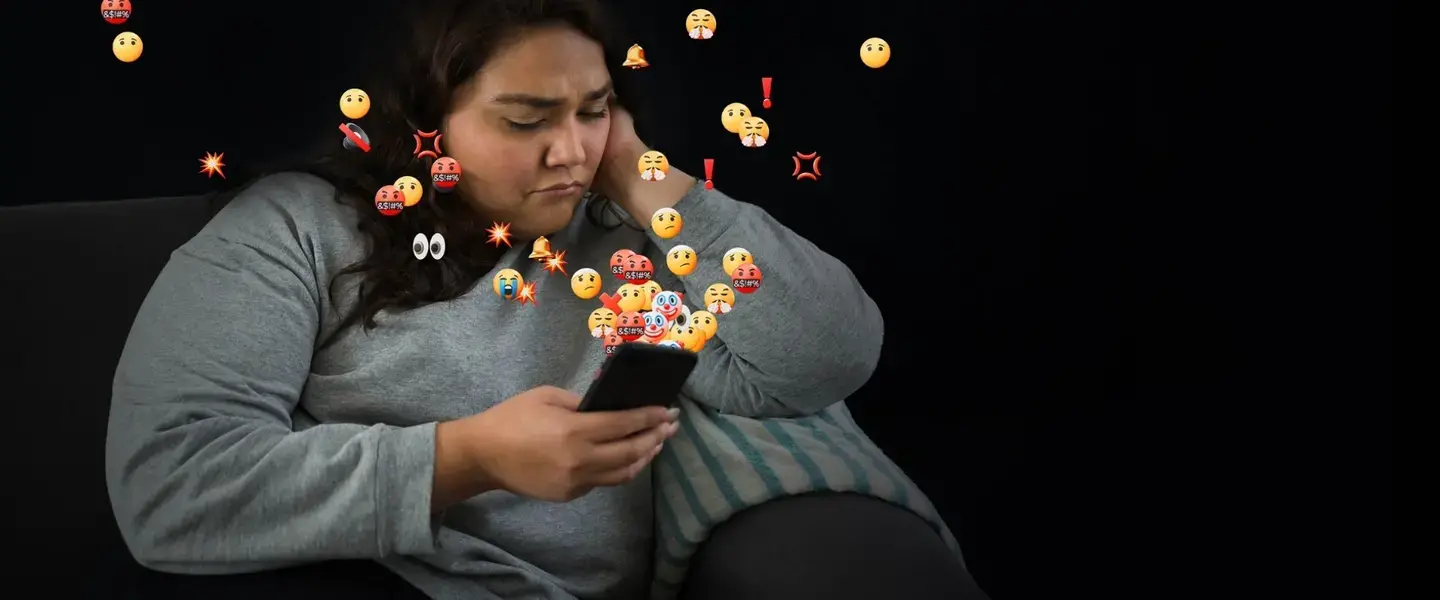 A woman looks at her phone concerned. AI powered abuse is threatening women and girls everywhere. There is no excuse for online abuse. Photo: UN Women