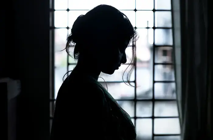 Vista de perfil de una mujer en una ventana.