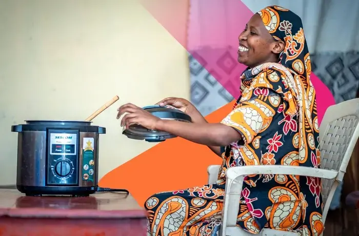 A UN Women programme beneficiary uses an improved cookstove, which has helped her significantly reduce the hours she spends preparing food. Photo: UN Women Tanzania.